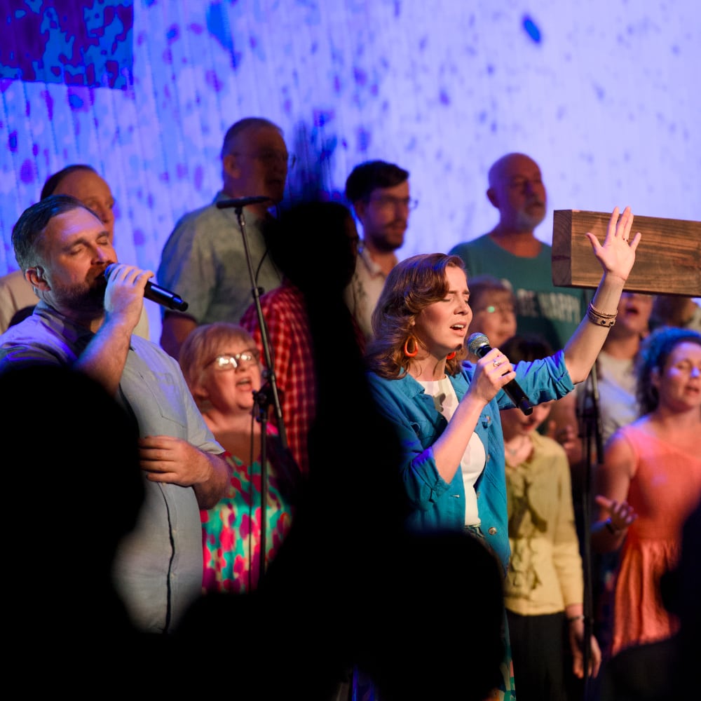 Hills Church | A man and a women worship while standing front of a choir | Hills Church Online | Worship